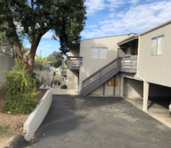 A concrete staircase leads to a balcony outside a building.