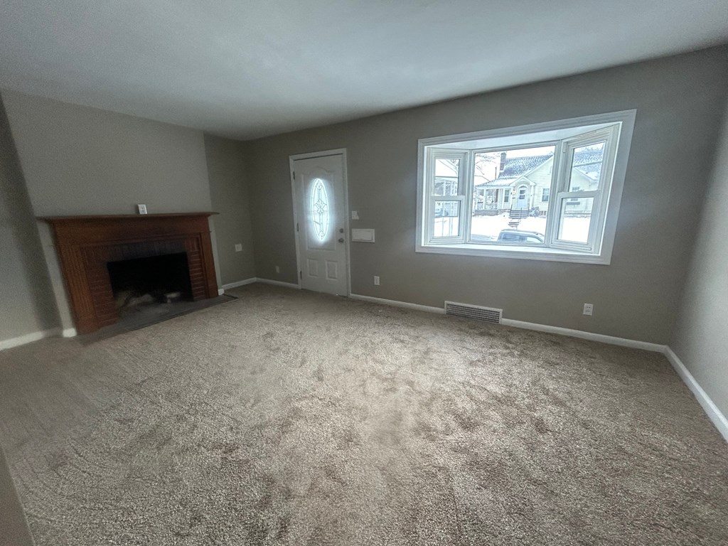 A room with a fireplace and a window.