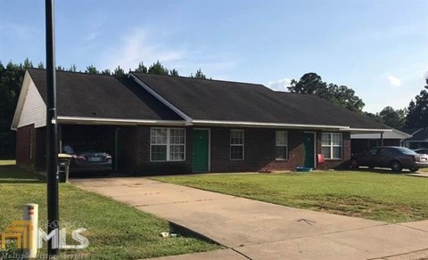 A house with a green door is for sale.