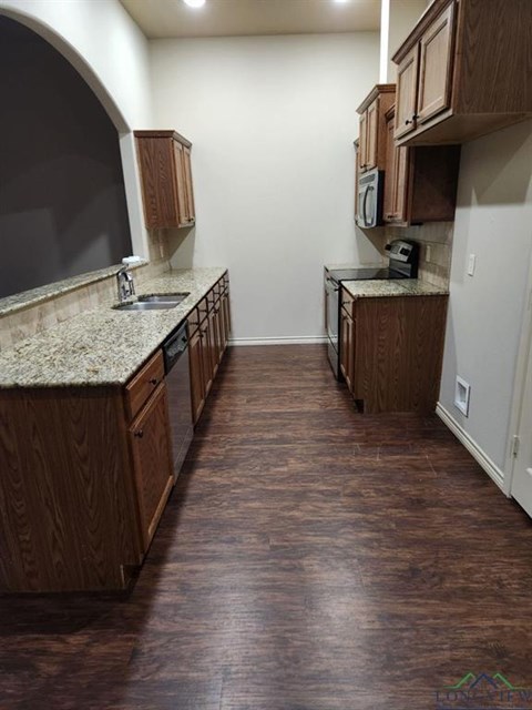 A kitchen with wooden cabinets and a granite countertop.
