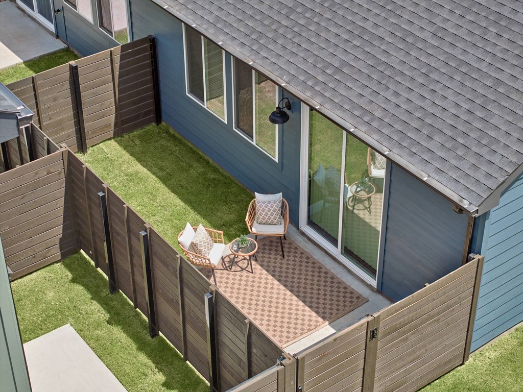 A person is sitting on a chair on a patio.