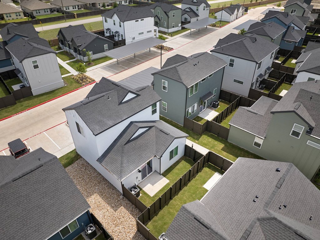 A bird's eye view of a residential neighborhood with houses and driveways.