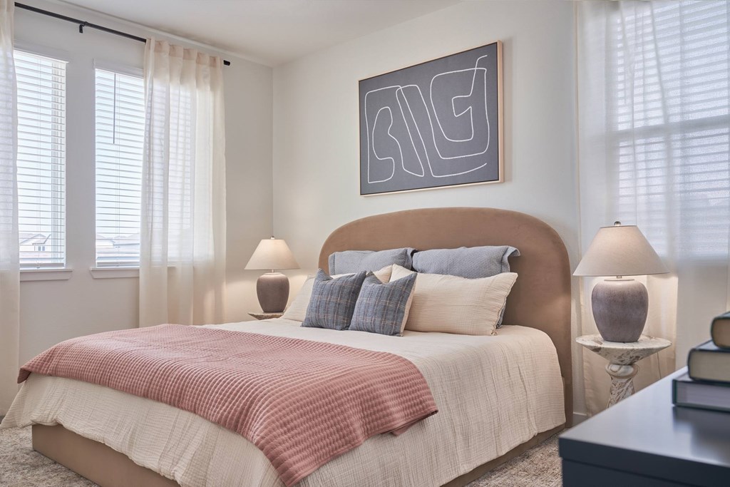 A bedroom with a large bed and a painting on the wall.