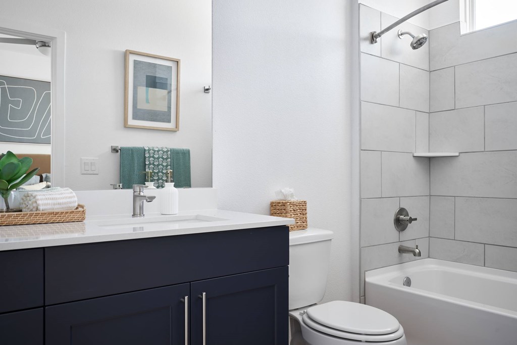 A bathroom with a white sink and a white toilet.