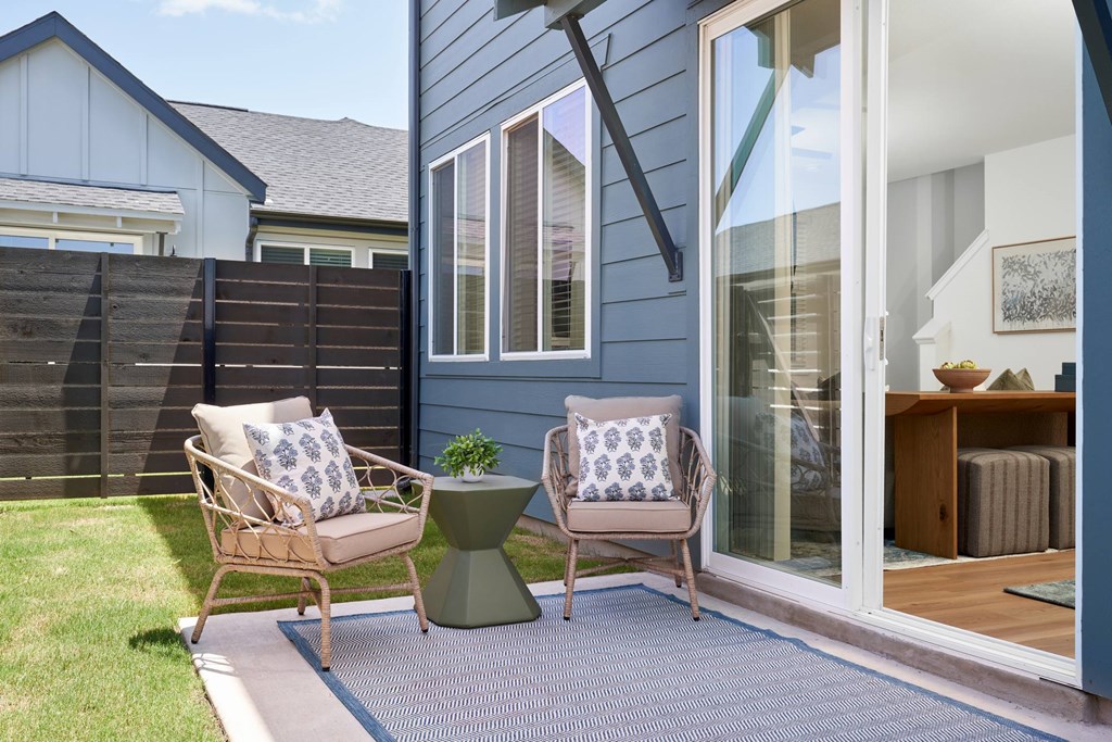 A patio with two chairs and a table.