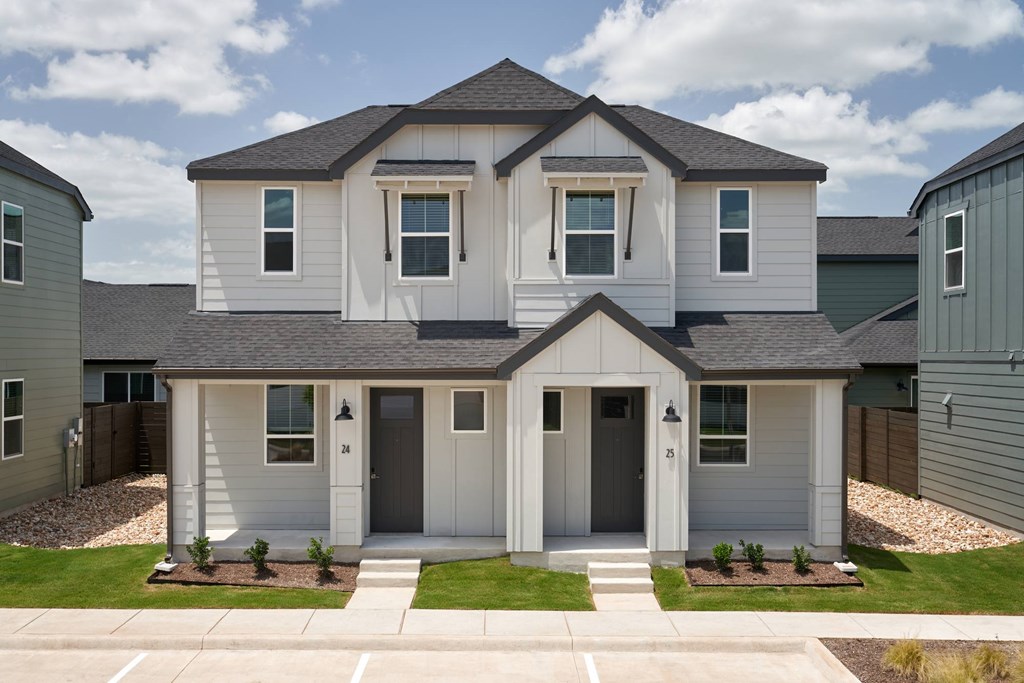 A two-story house with a grey roof and white walls.