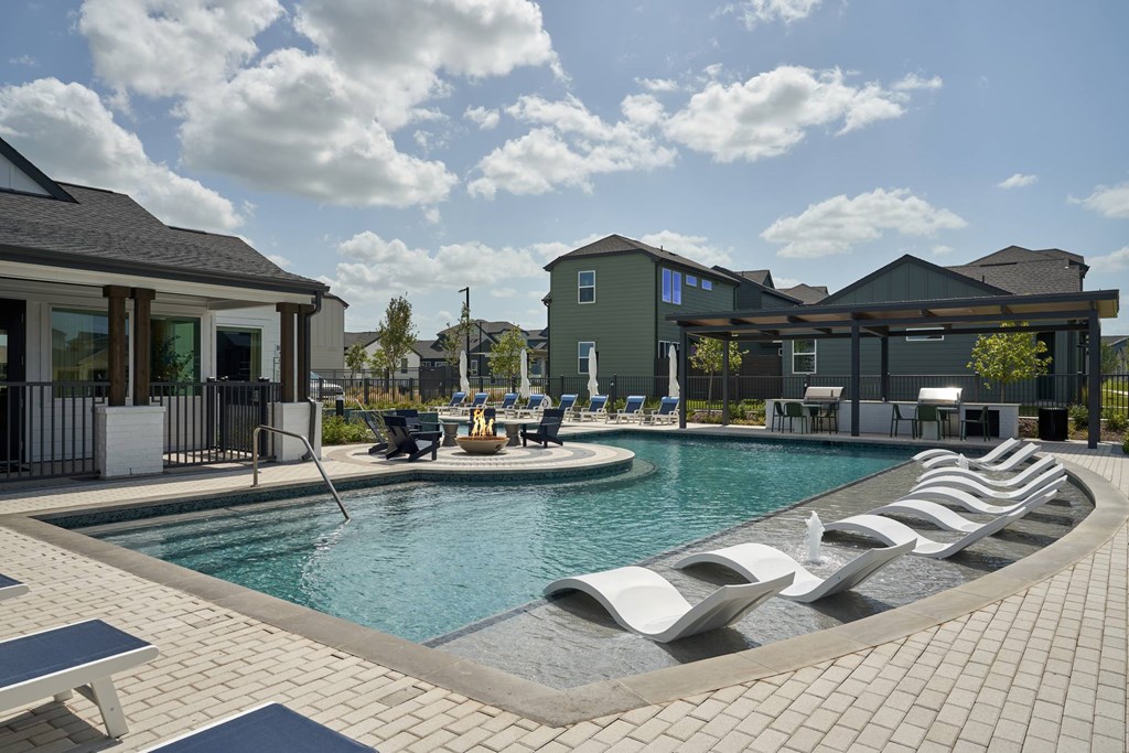 A pool with a white and black striped lounge chair.