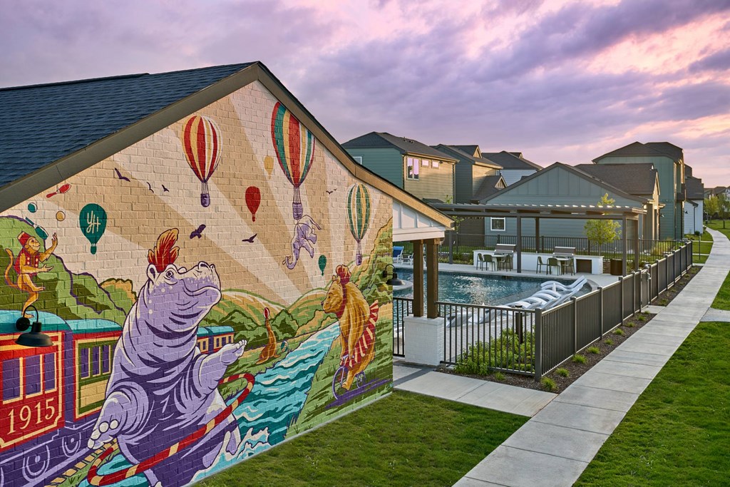 A mural of a hippo riding a train with the year 1915 on it.
