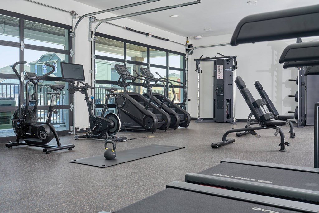 A gym with treadmills, elliptical machines, and other exercise equipment.