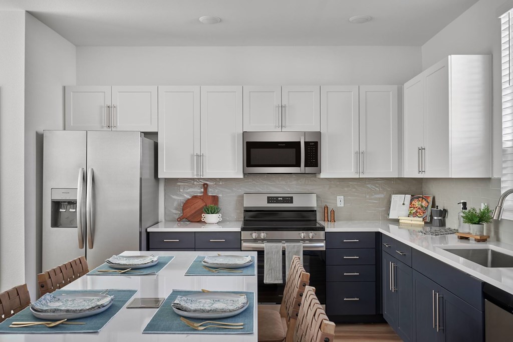 A modern kitchen with a dining table set for two.