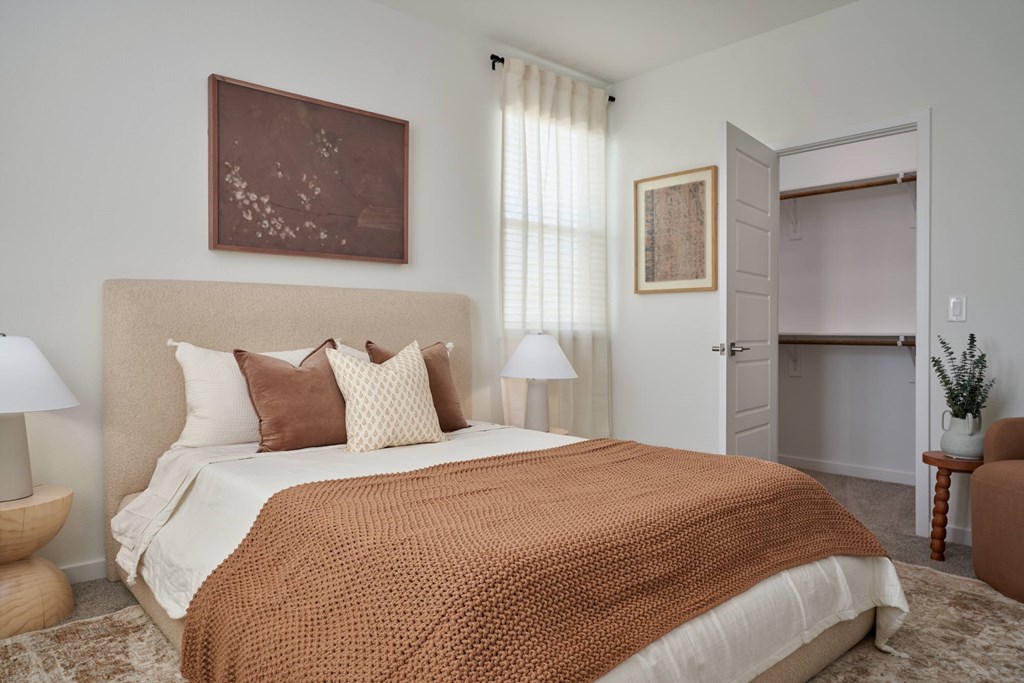 A bedroom with a large bed and a brown blanket.