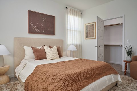 A bedroom with a large bed and a brown blanket.