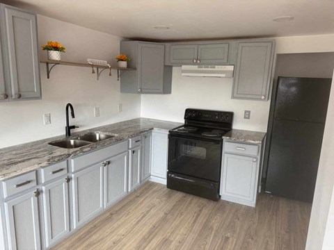 A kitchen with a black oven and a black refrigerator.