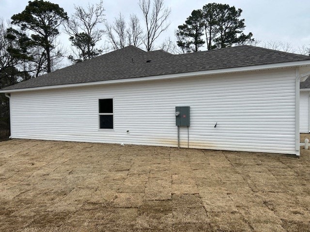 A white barn with a grey roof and a grey door.