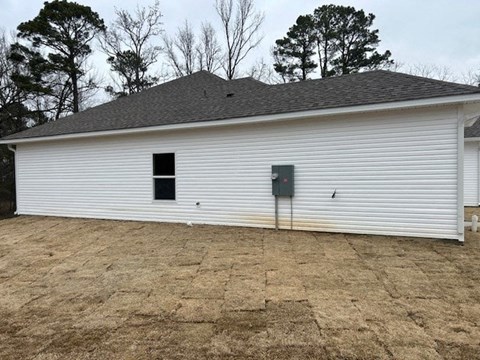 A white barn with a grey roof and a grey door.