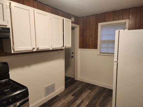 A kitchen with white cabinets and a black stove top oven.