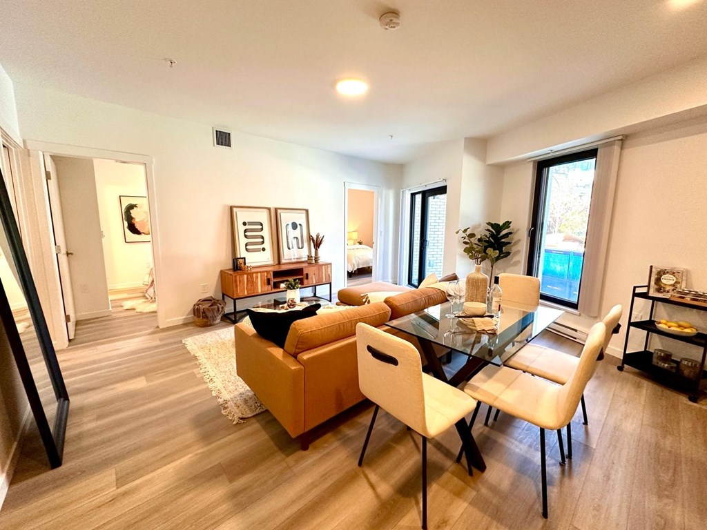 A modern living room with a glass table and white chairs.