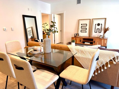 A dining room with a glass table and chairs.