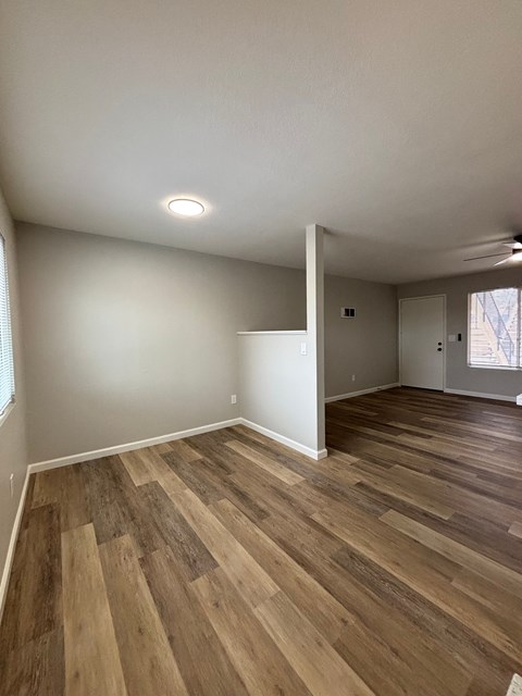 A room with wooden flooring and white walls.