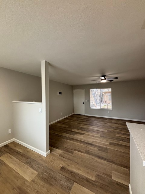 A room with wooden flooring and a ceiling fan.