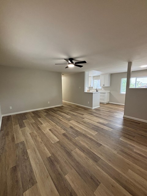 A room with wooden flooring and a ceiling fan.