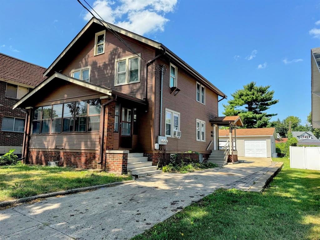 A house with a brown brick exterior and a white garage door.