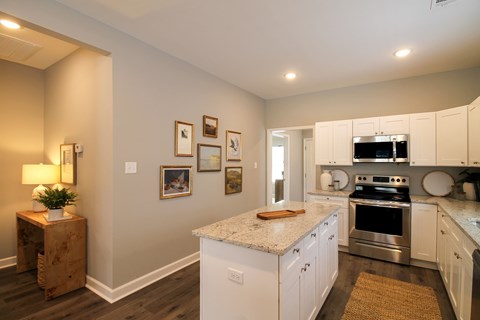 A kitchen with white cabinets and a granite countertop.