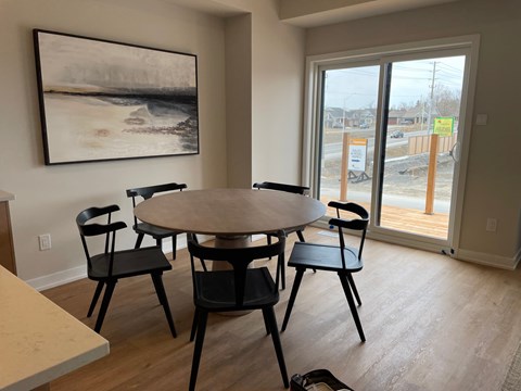 A dining room with a round table and four chairs.