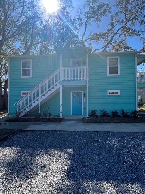 A blue house with a white door and a small porch.
