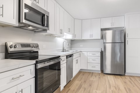 A kitchen with white cabinets and stainless steel appliances.