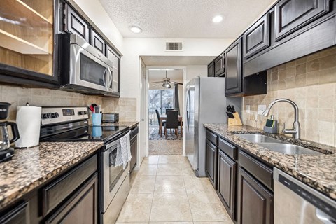 A kitchen with black cabinets and granite countertops.