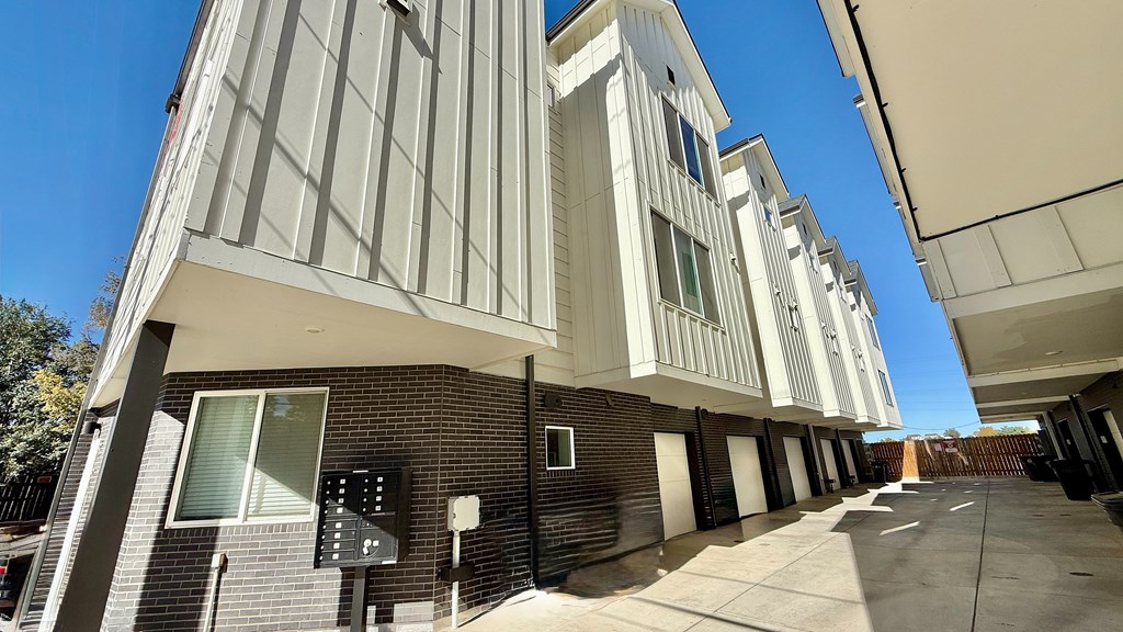 A modern kitchen with a white countertop and wooden cabinets.