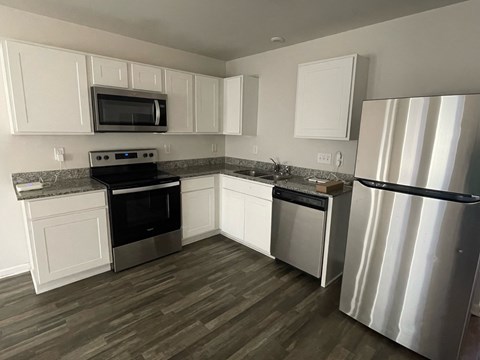 A kitchen with white cabinets and stainless steel appliances.