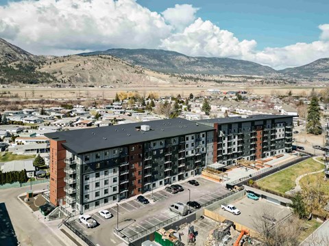A large apartment complex with a parking lot in front.