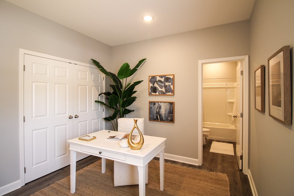 A white desk with a vase and a plant on it.