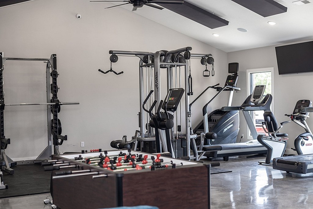 A basketball court is surrounded by a fence and there are people playing basketball on it.