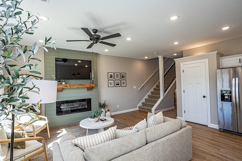 A living room with a grey couch and a fireplace.