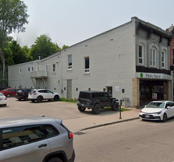 A grey building with a sign that says Men's Shop.