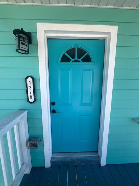 A blue door with a mailbox and number 137 on the wall.