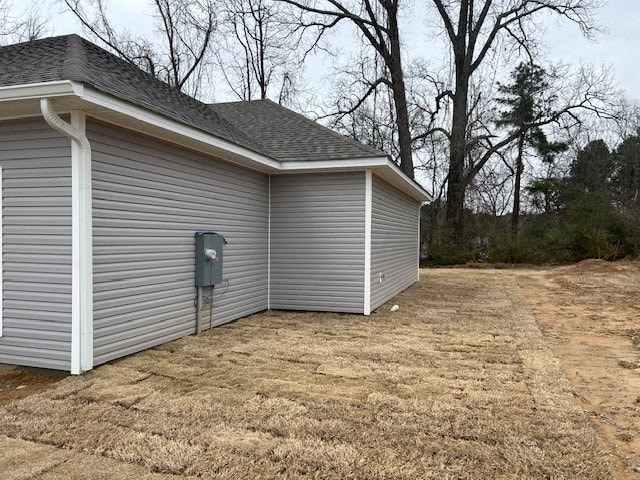 A metal garage door is closed and the garage is white.