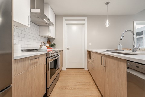 A modern kitchen with wooden cabinets and stainless steel appliances.