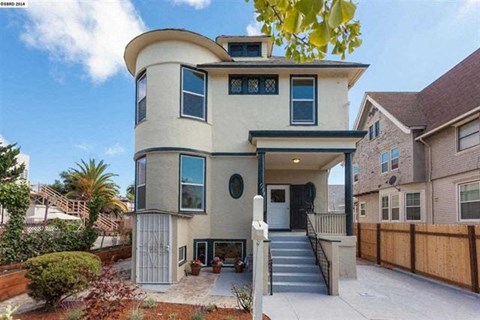A modern two-story house with a curved roof and a front porch.