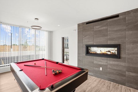 A pool table with a red cloth and two pool balls on it.
