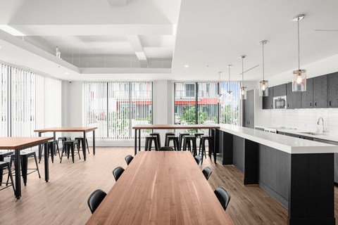 A modern dining room with a long wooden table and black chairs.