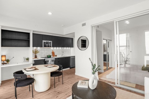 A modern kitchen with a dining table and chairs.