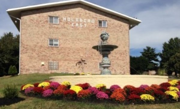 A building with a fountain in front of it and the words "Holabird Estate" on the top.