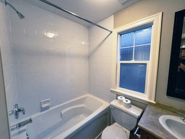 A white toilet sits next to a bathtub in a bathroom.