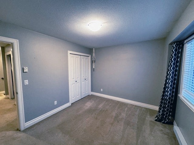 A room with a white door and carpeted floor.