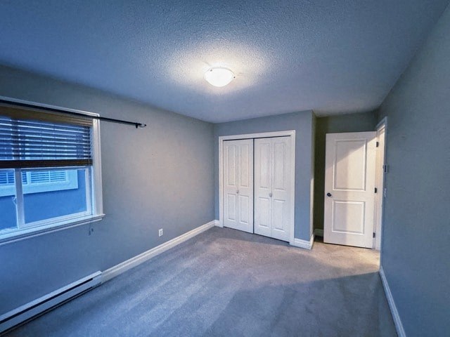 A room with a window, a white door, and a carpeted floor.
