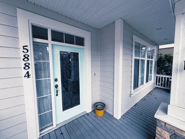 A white house with a blue door and a yellow bucket on the porch.